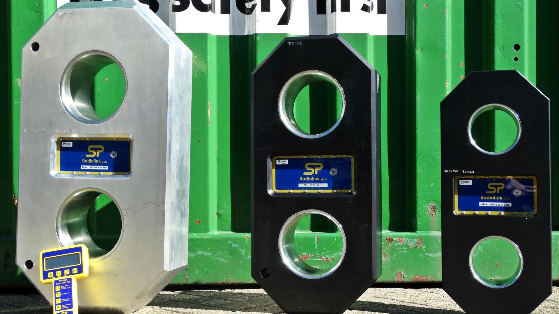 3 different sizes of Loadlink stood next to each other in front of a green shipping container
